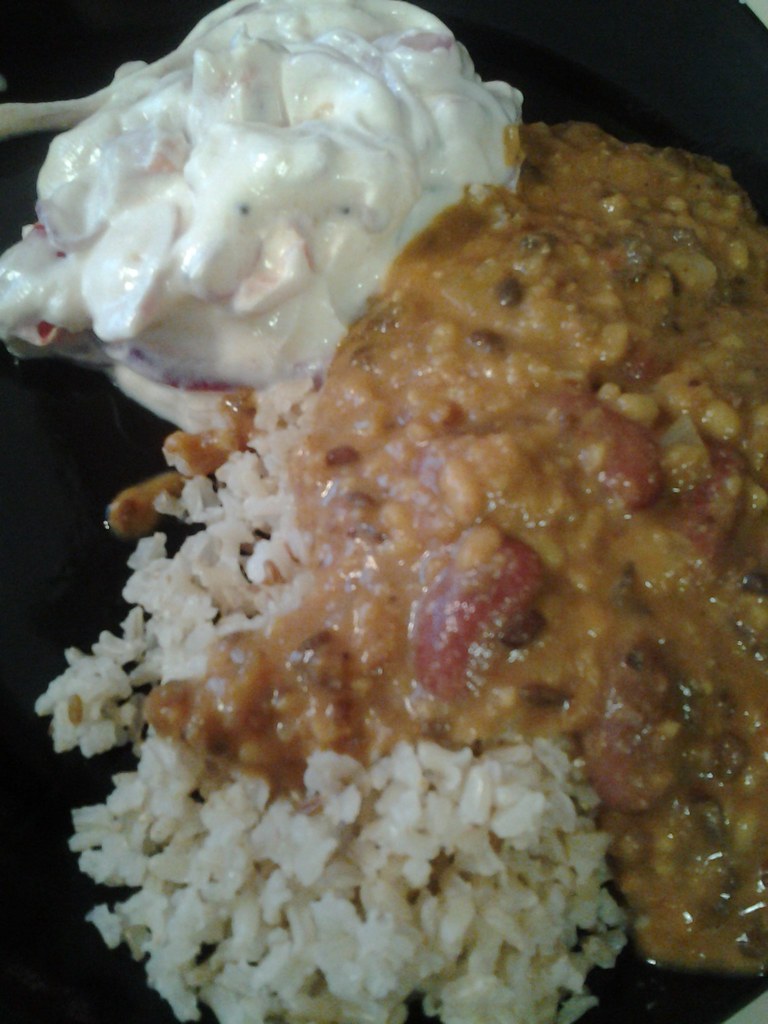 Close-up of plated food: meat with rice and whipped cream topping